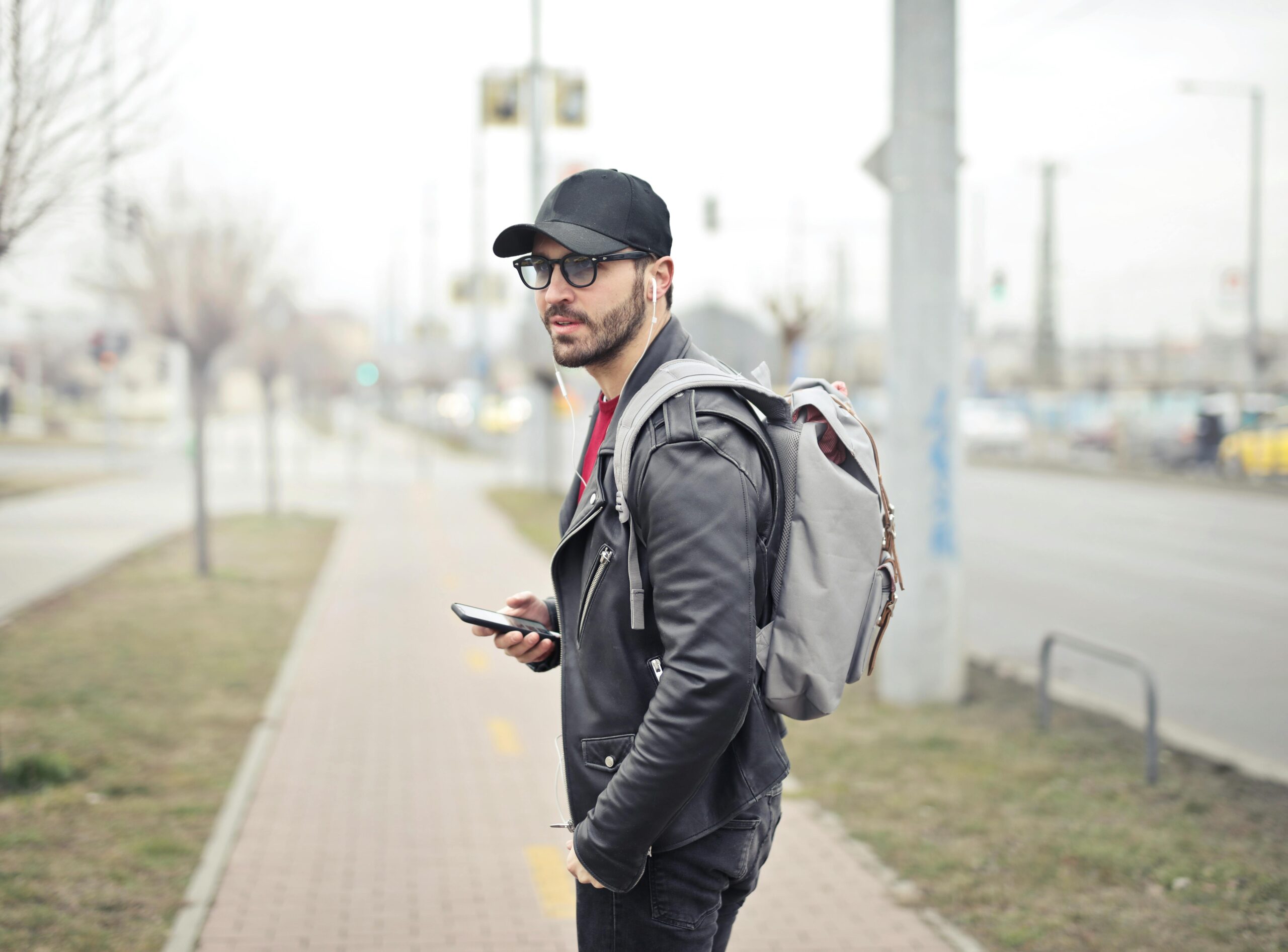 Inicio A fashionable young man in Budapest checking his smartphone on a busy street.